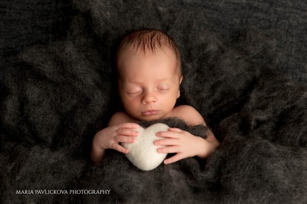 newborn baby holding heart